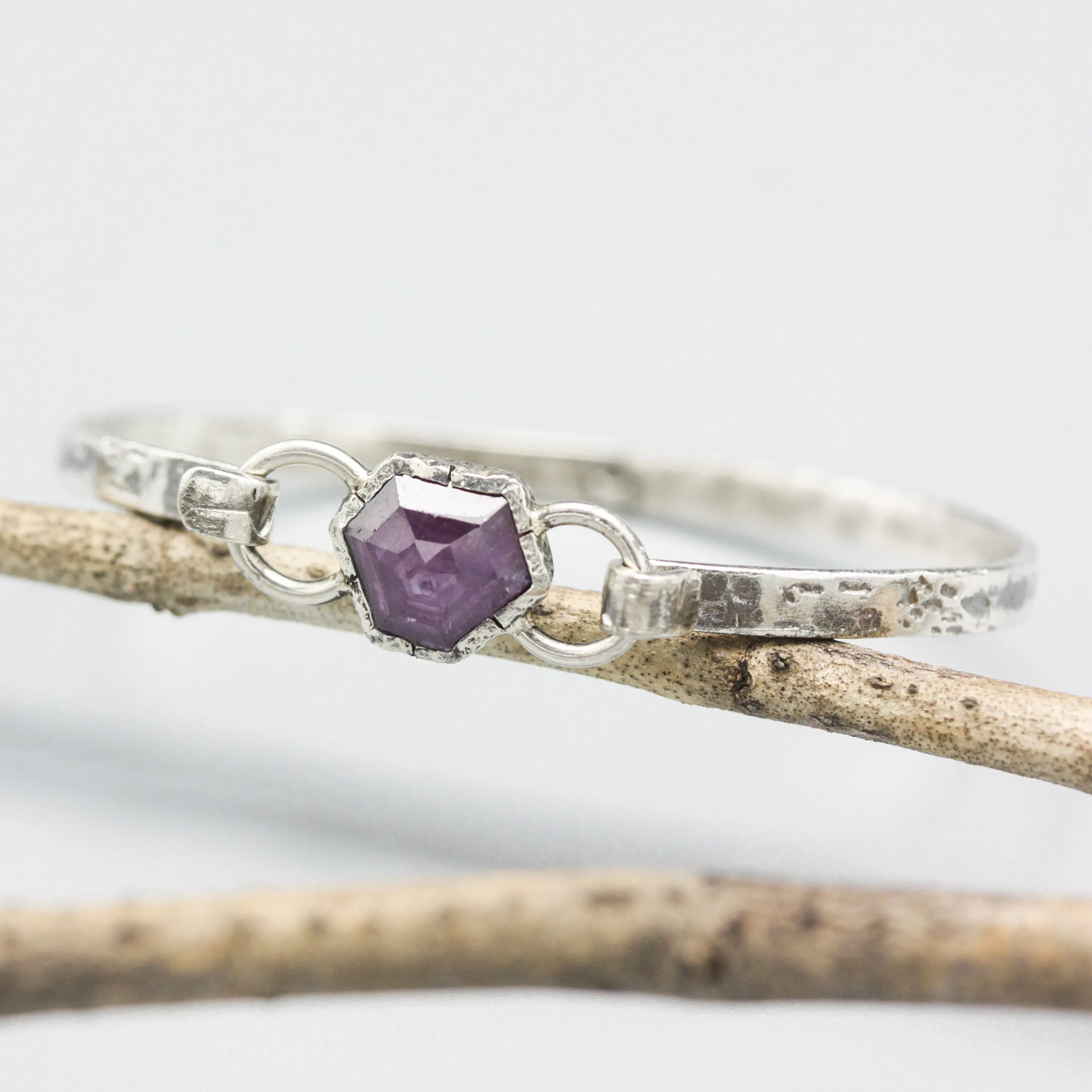 Pink sapphire bangle bracelet in silver bezel setting with oxidized sterling silver with texture band