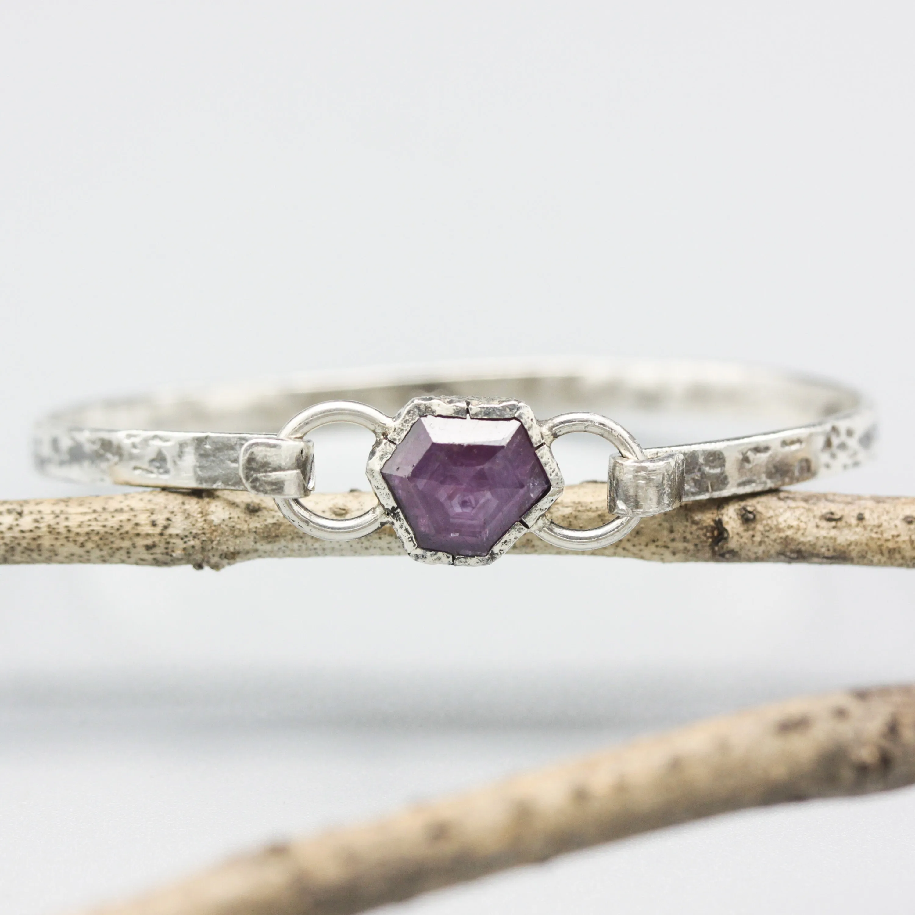 Pink sapphire bangle bracelet in silver bezel setting with oxidized sterling silver with texture band